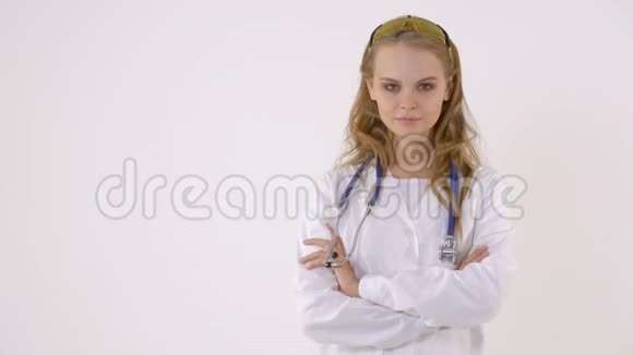 一位身穿白大褂的漂亮女医生看着镜头双臂交叉站立时面带微笑视频的预览图