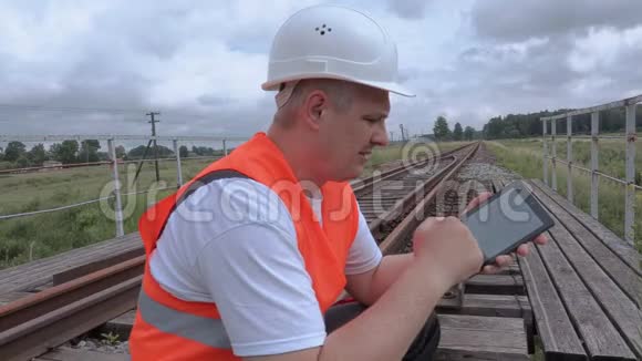 铁路工人在铁路桥上使用平板电脑视频的预览图