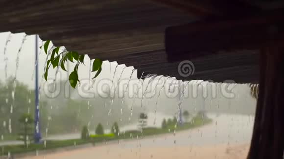 一场大雨和水从一栋建筑的屋顶上滑落的慢镜头视频的预览图