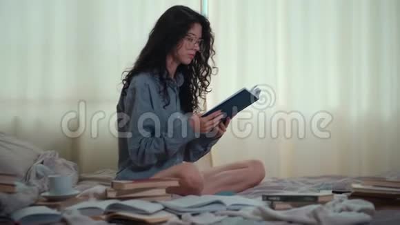 早上床上有书和咖啡的黑发美女视频的预览图