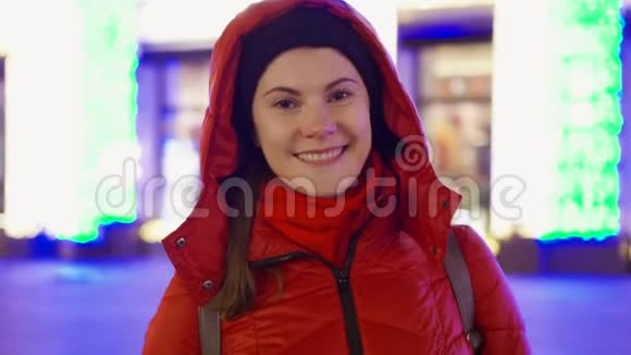 微笑的女人穿着外套站在装饰着花环的街道上新年圣诞节欧洲冬季视频的预览图