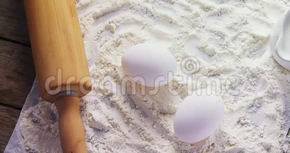 面粉鸡蛋和擀面杖放在桌上的黄油纸上视频的预览图