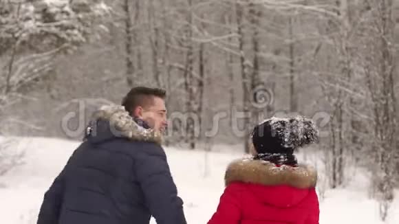 可爱的夫妇在冬季公园散步微笑视频的预览图