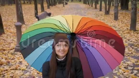 秋天公园里一个年轻漂亮的女孩独自在伞下视频的预览图