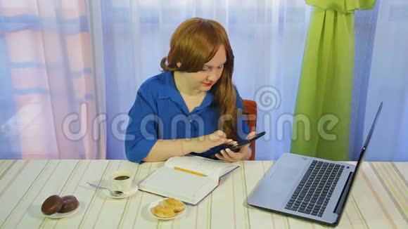 一个棕色头发的女人在一张桌子上的咖啡馆里工作手提电脑和喝咖啡视频的预览图