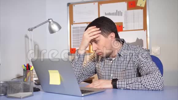 厌倦了办公室工作人员使用笔记本电脑他精疲力竭几乎睡着了视频的预览图