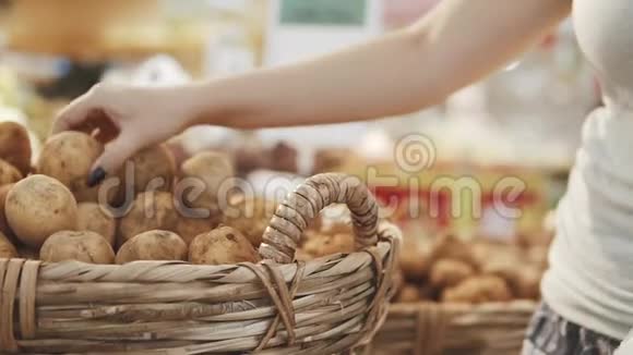 年轻漂亮的女人在超市为家人买新鲜健康的土豆和蔬菜选择手臂视频的预览图