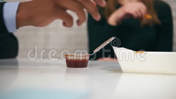 年轻的非裔美国人在工作时用慢动作在午餐时用手蘸鸡块蘸酱的特写镜头视频的预览图