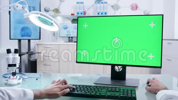 男性医生双手操作绿色屏幕电脑视频的预览图
