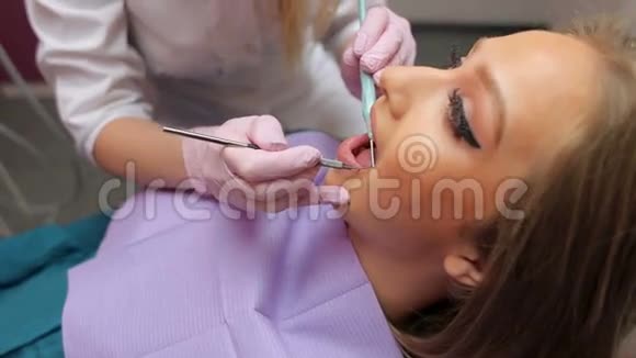 女医生在牙科诊所检查一个年轻女孩牙齿视频的预览图