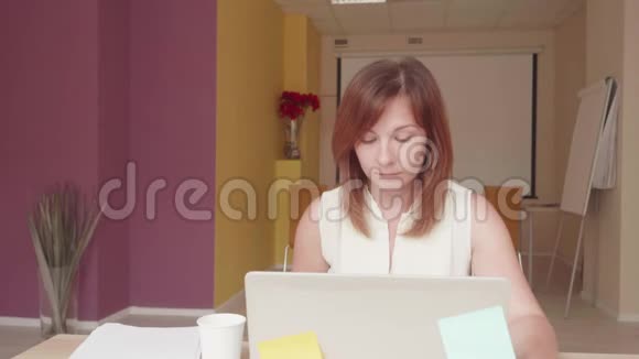 持不同政见的女人坐在笔记本电脑前喝水在膝上泼水视频的预览图