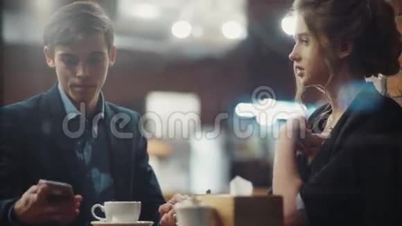 年轻夫妇交谈活泼喝咖啡在一家漂亮的现代咖啡馆约会在市中心视频的预览图