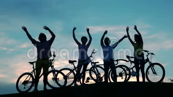 骑自行车的人在夕阳的天空中挥舞着双手视频的预览图