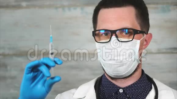 男性科学家或医生穿着白色外套戴着防护面罩手持注射器视频的预览图