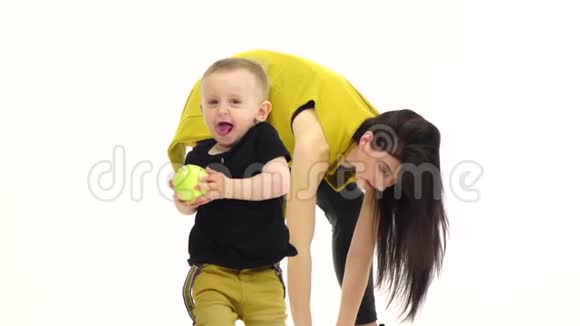 一个手里拿着苹果的孩子从他妈妈身边跑掉了白色背景慢动作视频的预览图
