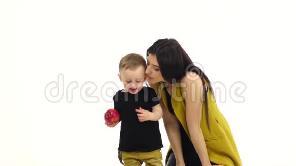 一个手里拿着苹果的孩子从他妈妈身边跑掉了白色背景慢动作视频的预览图