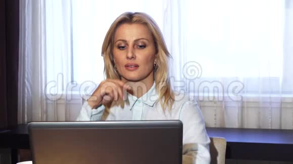 商务女士坐在笔记本电脑旁一边喝咖啡视频的预览图