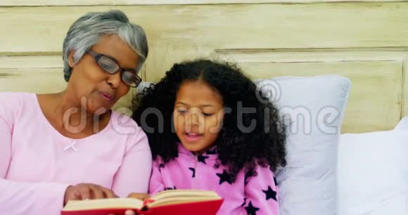 祖母和女儿在沙发上看书视频的预览图