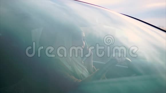 一位年轻的阿拉伯妇女正坐在她的私人汽车里和丈夫通电话视频的预览图