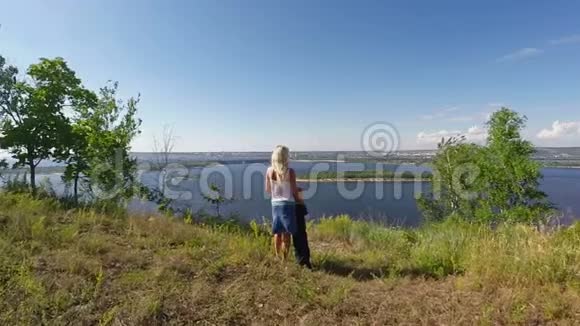 在伏尔加河的岩石河岸上有儿子的女人视频的预览图