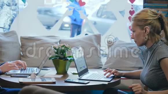 一个女人和一个男人在咖啡馆里用笔记本电脑工作的肖像视频的预览图