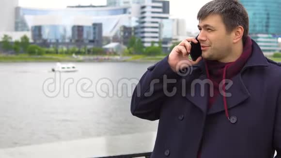 一个男人在城市景观的背景下用手机说话视频的预览图