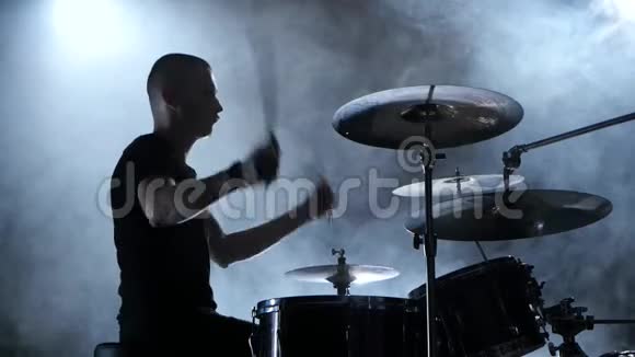 音乐家在鼓上演奏旋律黑烟背景侧视剪影式视频的预览图