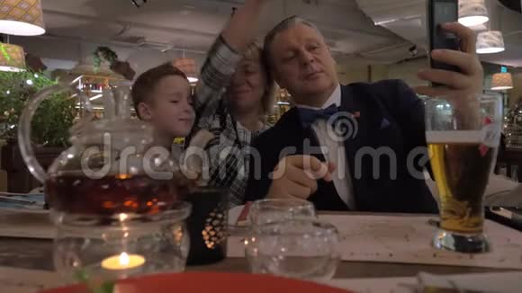 祖父母和孙子在餐馆的家庭晚餐中自拍视频的预览图