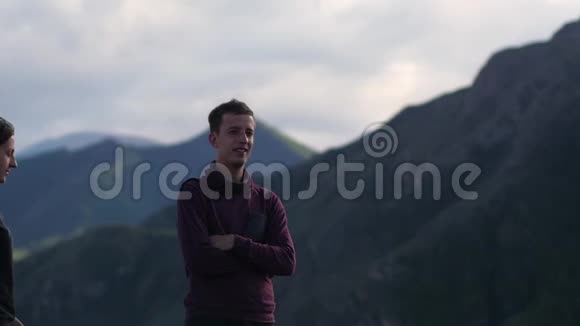 两个人在山的背景下散步蜜月在群山的背景上亲吻风力发展视频的预览图