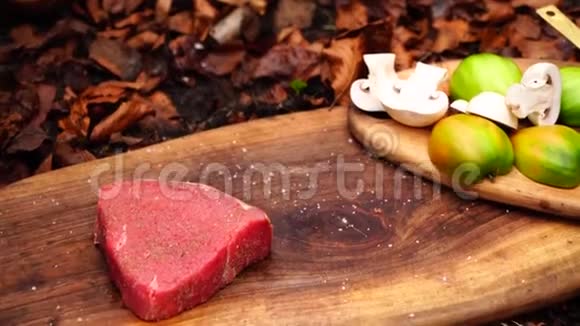 在森林营火烧烤盘里男人用手在烤盘上扔出令人难以置信的新鲜肥牛排粉红肉视频的预览图