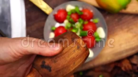 在森林的木板上用手把胡椒放进新鲜切好的蔬菜碗里沙拉番茄胡椒洋葱视频的预览图