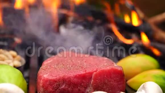 在森林营火中在烤盘上的新鲜切菜和大块牛肉牛排粉红肉上美丽的近景视频的预览图