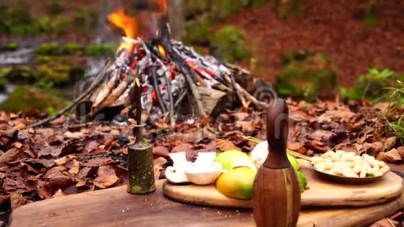 在舒适的壁炉中新鲜的切菜在木板上燃烧着橙色的火焰野生的秋天森林视频的预览图