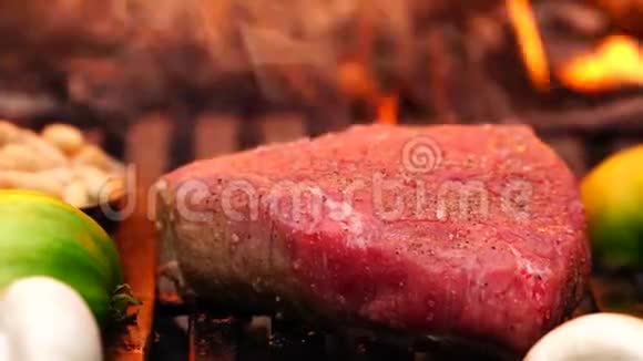 精彩的近距离观看美味的牛肉牛排肉蔬菜在森林营地的烤盘上准备食物火焰视频的预览图