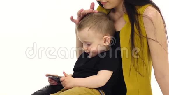 女人和她的孩子坐在地板上她抚摸着他的头发白色背景视频的预览图