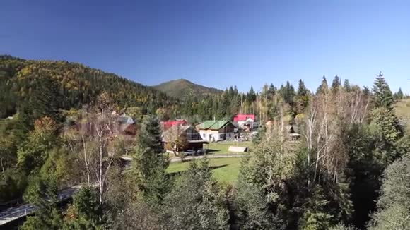 在阳光明媚的一天在多山的房子里秋天的森林视频的预览图