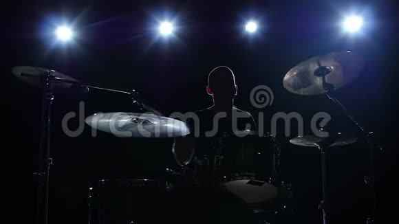 鼓手在鼓上大力演奏旋律黑色背景背光剪影慢动作视频的预览图