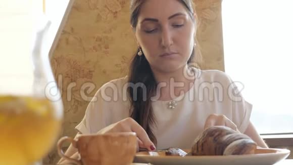 餐桌上的美女在吃羊角面包视频的预览图