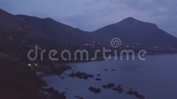4k日落空中飞行镜头透过蓝色的海洋和紫色的云层视频的预览图
