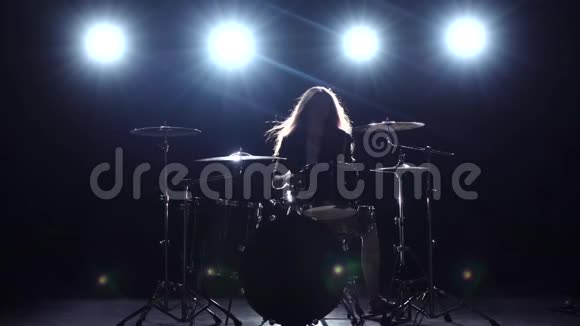 鼓手在摇滚音乐会上演奏黑烟背景剪影慢动作视频的预览图