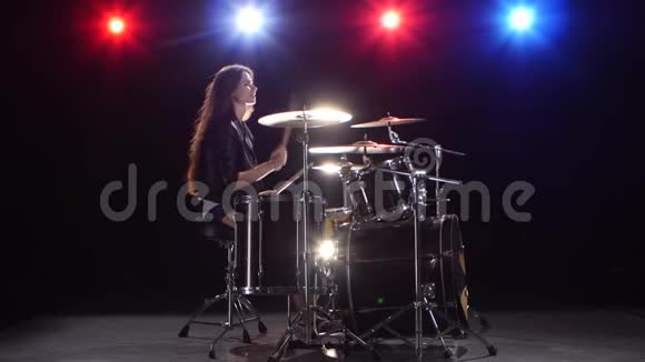 拿着筷子的女鼓手敲打有节奏的音乐黑色背景红光蓝侧视图视频的预览图
