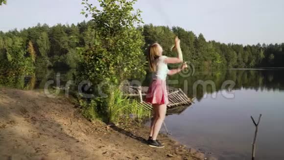金发少女渔夫正在森林湖上钓鱼穿短裙的女人学会在大河上钓鱼视频的预览图