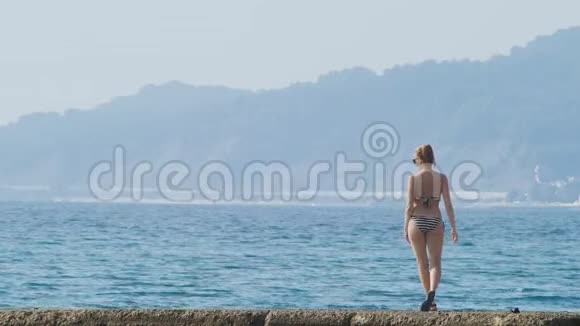 海湾中岛屿的景色远程摄影在防波堤上的女人在雾中看海岸4K慢慢地视频的预览图