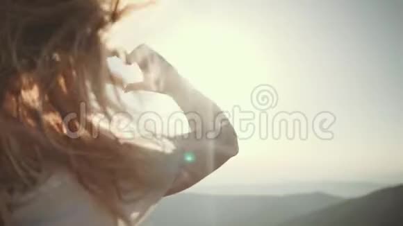 女孩在阳光下用手指做心脏标记视频的预览图