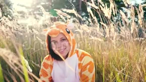 一个穿着长颈鹿服装在城市公园散步的年轻女孩学生的情感肖像视频的预览图