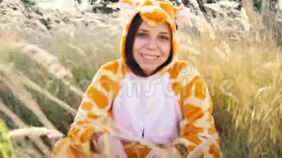 一个穿着长颈鹿服装在城市公园散步的年轻女孩学生的情感肖像视频的预览图