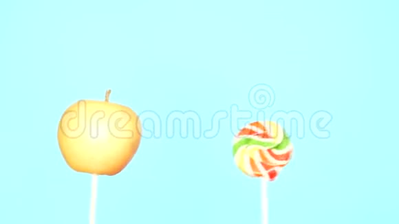 健康和不健康食品的概念在明亮的蓝色背景下用糖果做苹果视频的预览图