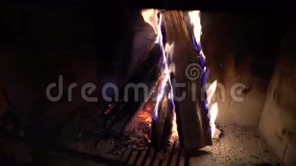 在黑暗中壁炉里燃烧的木柴上的火焰视频的预览图