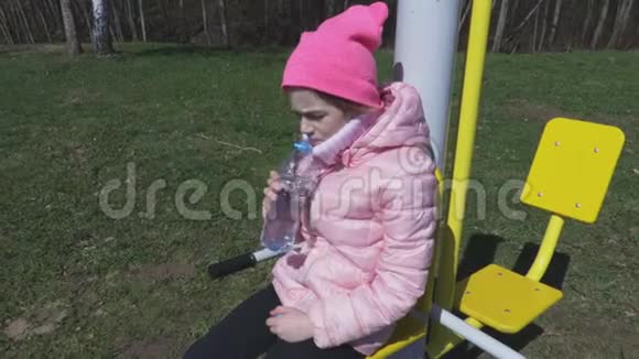 坐在训练机和饮用水上的小女孩视频的预览图