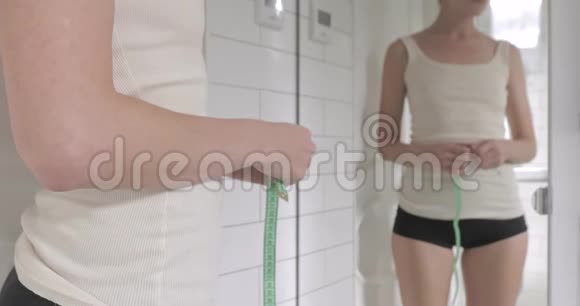 在浴室里测量腰镜的女人视频的预览图